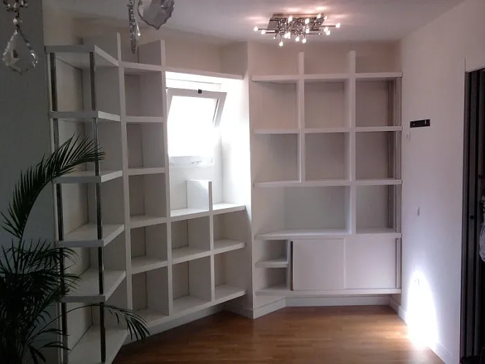 Librería blanca de rincón con baldas de distintas alturas