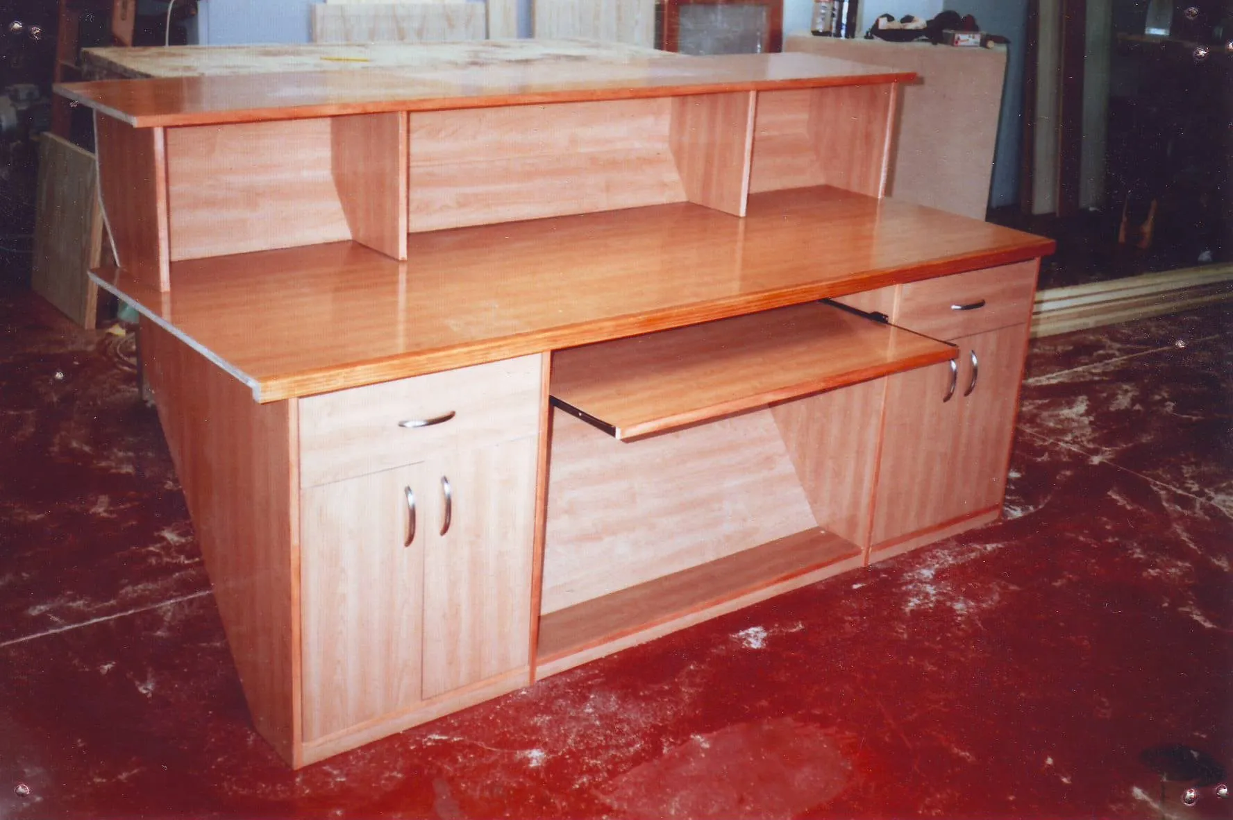 Mueble escritorio de madera clara con bandeja extraíble, amoldado a la pared