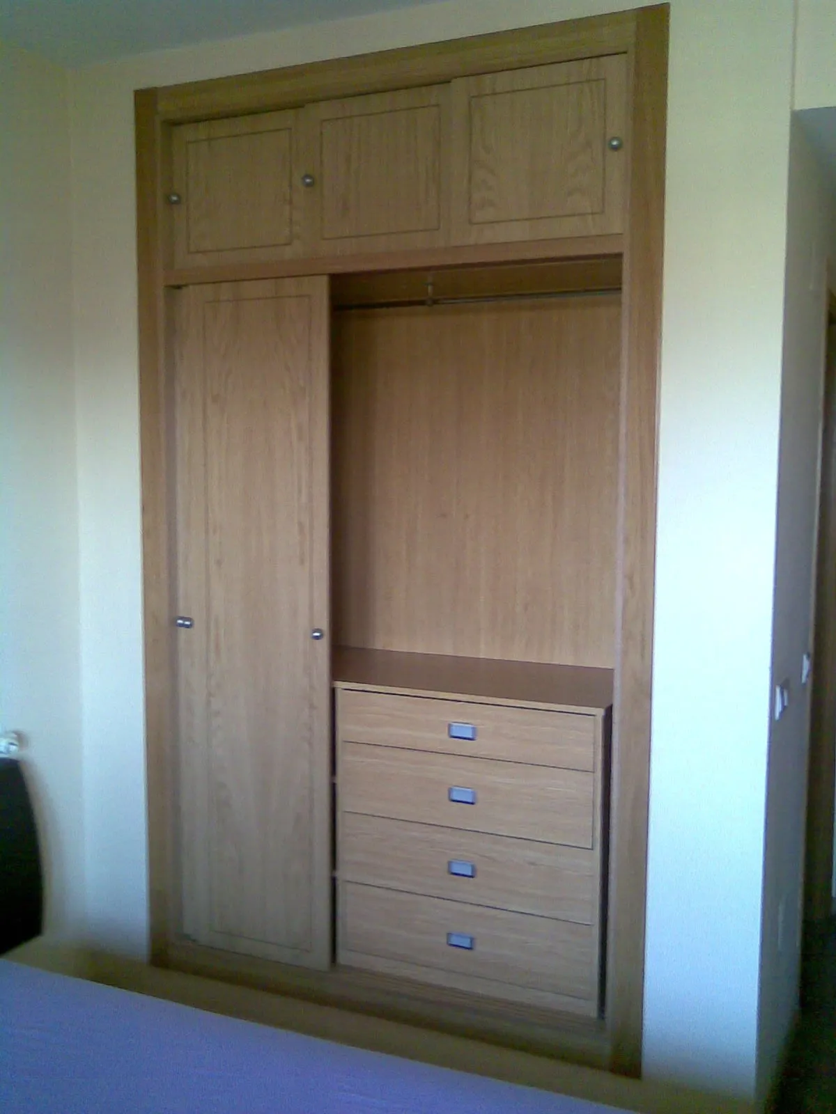Ropero de madera clara con altillo, abierto, con cajonera interior