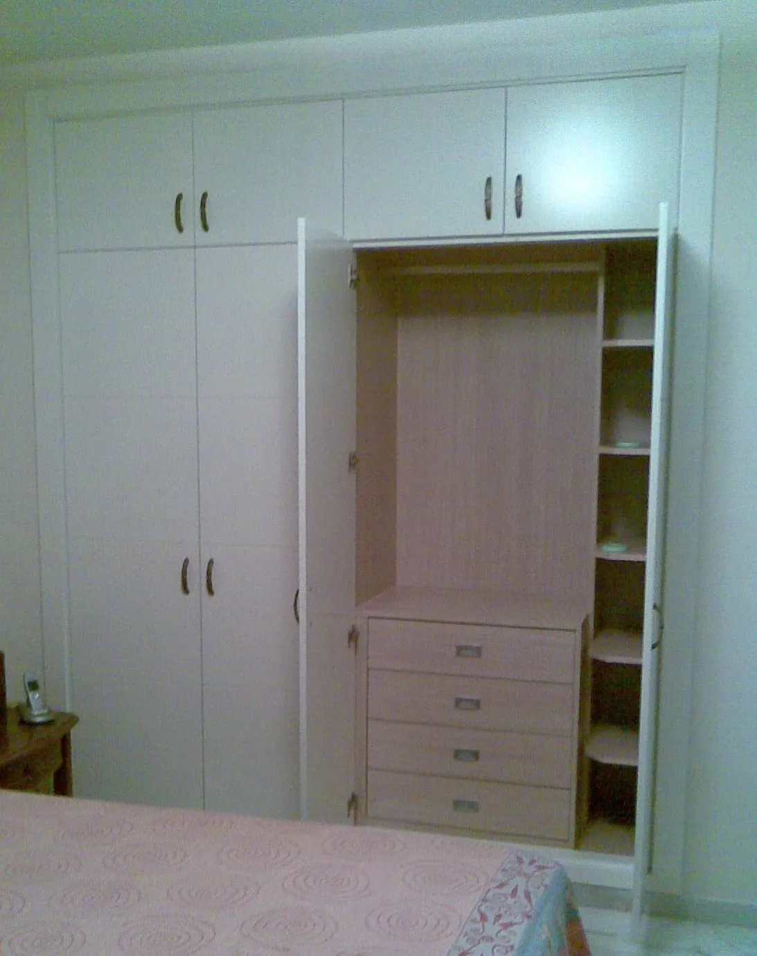 Ropero blanco abierto con el interior forrado en color madera