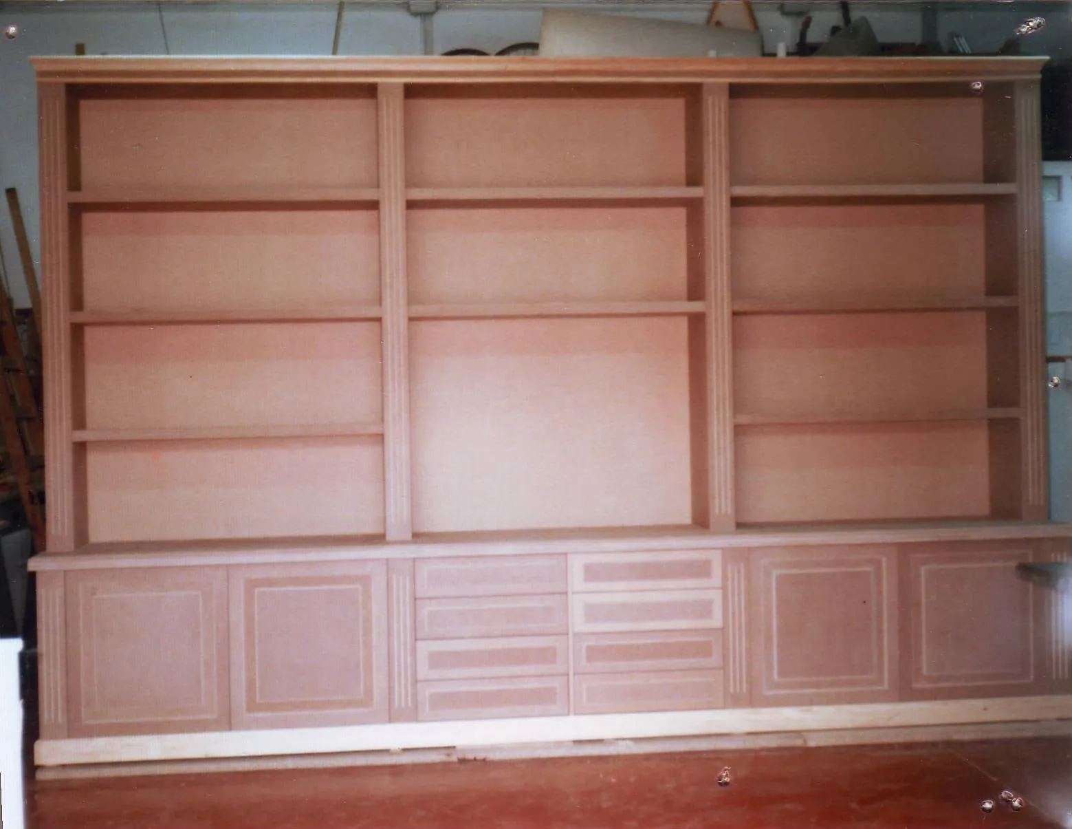 Mueble de salón de cerezo en crudo, con baldas y cajones, antes de barnizar
