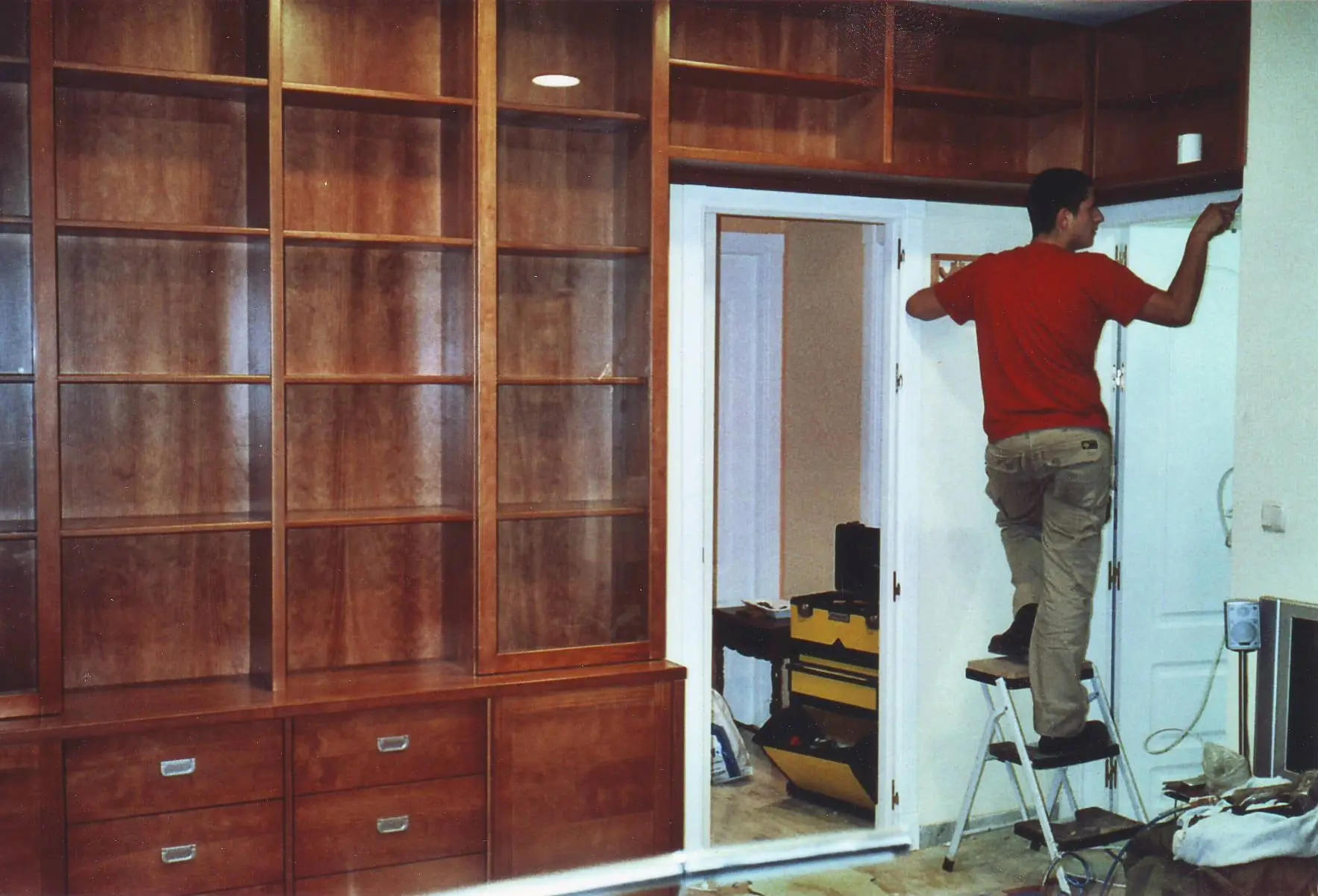 Librería de cerezo que rodea una puerta, durante el montaje