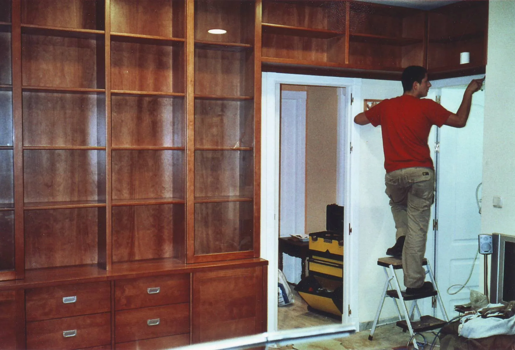 Librería de cerezo que rodea una puerta, durante el montaje